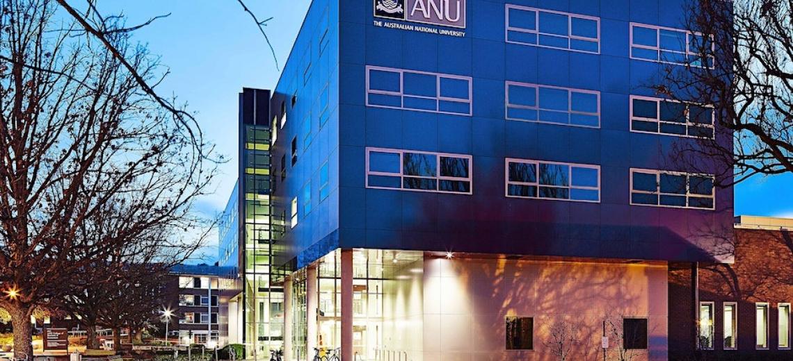 Exterior of building at dusk. Tree in the foreground